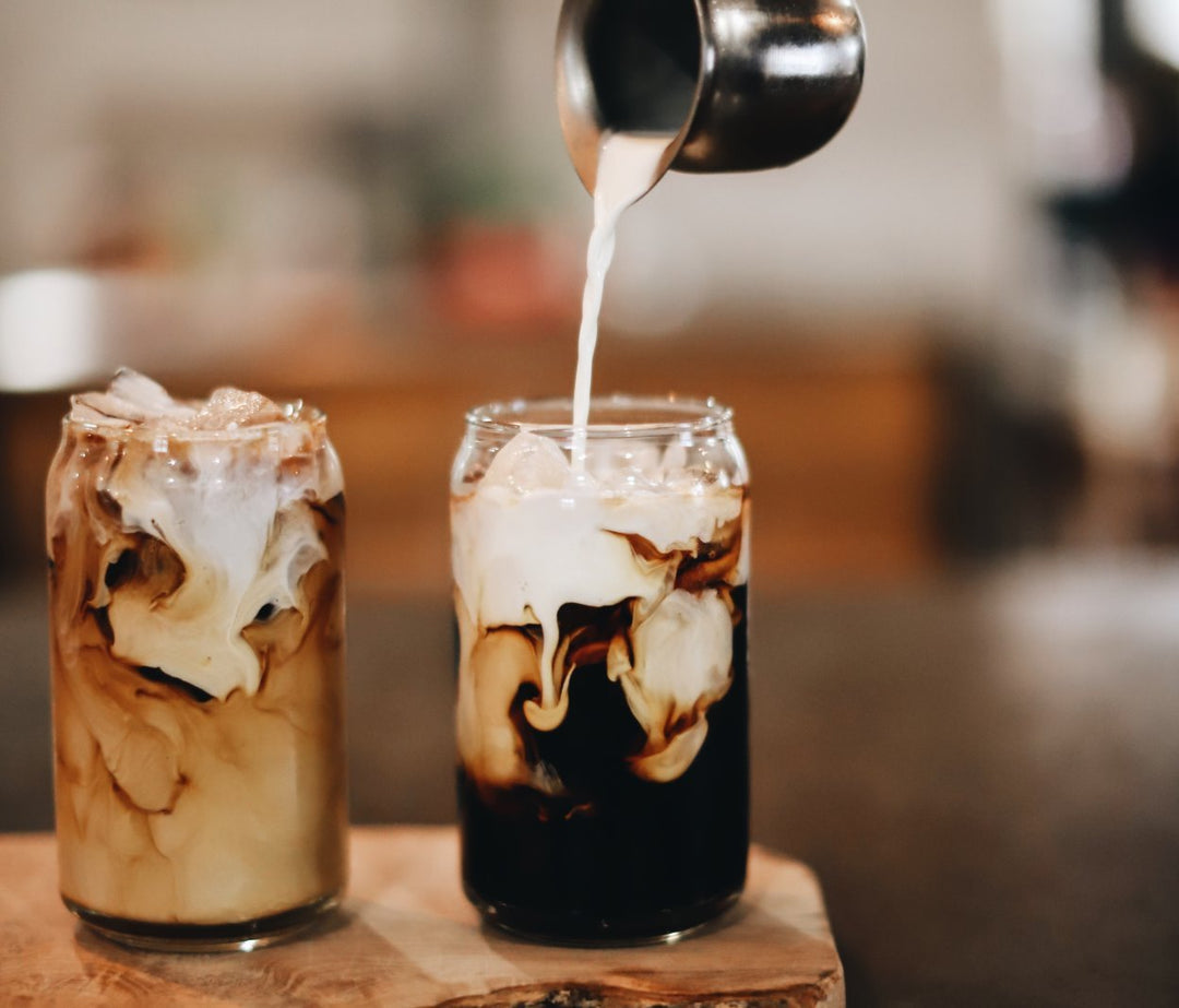two glasses showcasing cold brewed coffee mixed with ice and cold milk