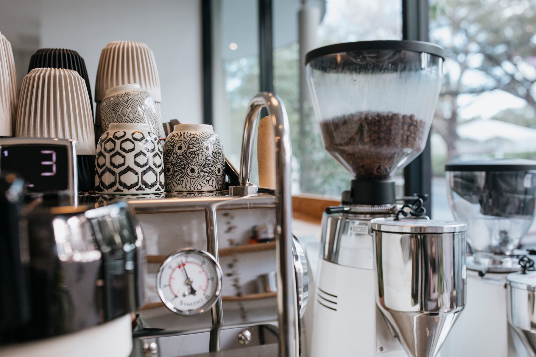 coffee machine with printed coffee mugs in background