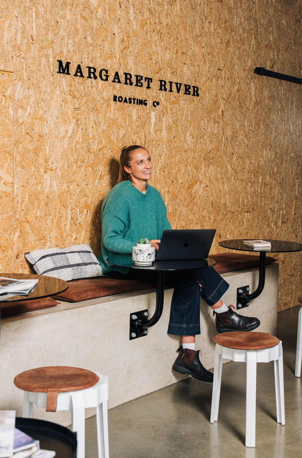 a female working on a laptop inside coffee roastery